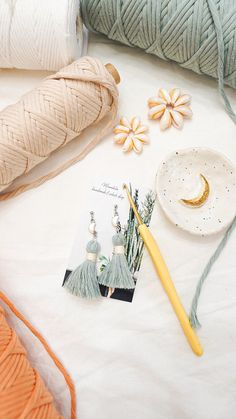 yarn, earrings and knitting needles on a white surface