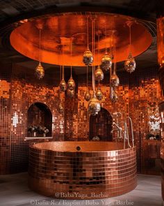 a bath room with a large round tub and lots of lights hanging from the ceiling