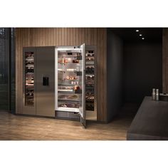 an open refrigerator in a kitchen with wooden walls and flooring, it is stainless steel