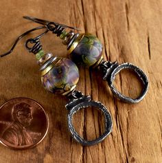 Smokey tones of aborigine and rich green in tribal style raku lampwork glass earrings. A deep plum purple is the base color of these gorgeous artisan glass beads, dappled with Wasabi green and hints of golden yellow. I have arranged the lampwork glass atop artisan pewter charms and accented them with touches of brass and Czech glass spacers in mauve and green. Handmade oxidized copper ear wires finish the design for a total length of 2.3 inches, and they are a comfortable weight for their size. Artisan glass lampwork beads from InspireGlassStudio on Etsy! Artisan pewter charms from Inviciti on Etsy! Your package will come to you gift wrapped in natural, and environmentally friendly materials. All my jewelry is 100% workmanship guaranteed. Any problem with construction or component failure Mauve And Green, Lampwork Bead Jewelry, Pewter Jewelry, Lampwork Earring, Plum Purple, Mixed Metals, Glass Earrings, Elegant Earrings, Lampwork Beads