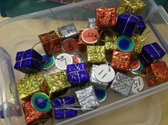 a plastic container filled with assorted wrapped gifts and numbers on it's sides