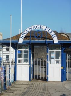 the entrance to swanage pier is blue and white with an arched doorway over it