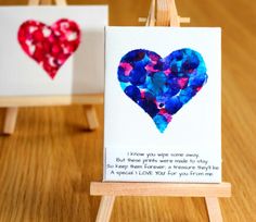 two little cards with hearts on them sitting on a wooden easel next to each other