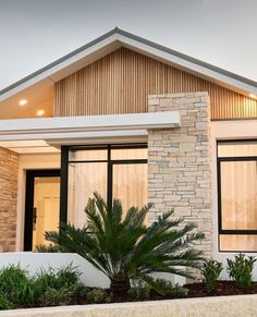 a modern house with large windows and plants in the front yard