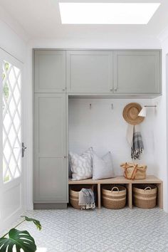 a white room with gray cabinets and baskets