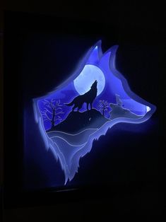 a wolf is standing on top of a hill in the dark with blue light coming from behind it