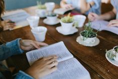 people sitting at a table with open books