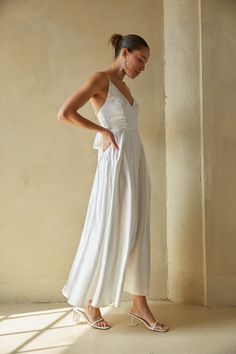 Say "I do" to the romantic Mary Bow Back Satin Maxi Dress. This white satin maxi dress features a v-neckline, open back, and bow detailing that makes this style irresistible. Style with some chic jewelry to add the finishing touch! Details Self: 98% Polyester, 2% Spandex Lining: 88% Polyester, 12% Spandex Back ZipperMaterial has minimal stretch Adjustable spaghetti straps Side bodice boning Hand wash cold / Hang dry Chic Rehearsal Dinner Dress, Beachy White Dress, Satin Flowy Dress, Bridal Fits, American Threads, Rehearsal Dinner Dresses, Bow Back, Satin Maxi, Satin Maxi Dress