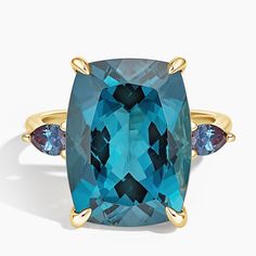 a blue stone ring with three stones on the band and two gold rings around it