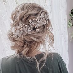 a woman with blonde hair is wearing a flowered headpiece in front of a window