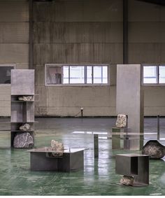 an empty room with several sculptures in the middle and one on the floor, all made out of concrete blocks