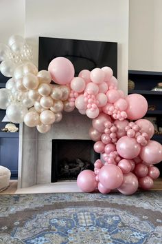 balloons are arranged in the shape of a letter on top of a fireplace mantel