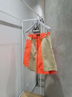 Cotton twill blend shorts with beige and neon orange panels and an asymmetric hem. please note that this short features a raw edge which will naturally shred over time. it also has a natural horn button with zipper closure and belt loops.    vendor colour: beige/orange    vendor style: fs09s-i0609    fabrication: 51% polyester 46% cotton 3% silk    imported.    hand wash cold with mild detergent. lay flat to dry. low iron on reverse if needed. dry clean. Spring Color Block Cotton Shorts, Orange Cotton Shorts For Spring, Trendy Orange Cotton Shorts, Orange Color Block Bottoms For Summer, Spring Orange Cotton Shorts, Summer Orange Color Block Bottoms, Feng Chen Wang, Colour Beige, Designer Clothes For Men