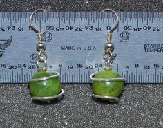 "These jade wrapped bead earrings are made from 10 mm nephrite jade beads and sterling round wire with sterling ear wires. They dangle just enough to be a little dressy but are still appropriate for day wear. Jade is a name given to two different types of stone, nephite and jadeite. The jade I use is nephrite, an amphibole mineral species of tremolite-ferroactinolite. The green is due to iron. Black spot inclusions of magnesite are often visible. My jade comes from British Columbia, Canada and i Nephrite Jade, Types Of Stones, Black Spot, Jade Beads, Jade Green, Beaded Dangles, Jade, Beaded Earrings, Natural Gemstones