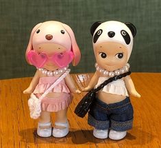 two dolls are standing next to each other on a table