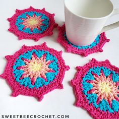 three crocheted coasters and a coffee cup on a white table with a mug in the middle