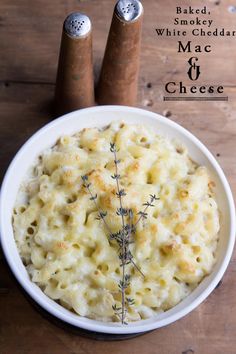 a white bowl filled with macaroni and cheese on top of a wooden table