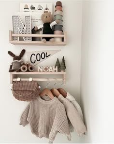 two wooden shelves holding stuffed animals and sweaters on top of each shelf, with the word cool hanging above them