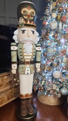 a nutcracker standing next to a christmas tree