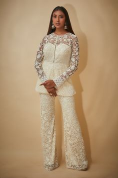 White peplum jacket with off-white cutdana, sequins and beaded hand embroidered floral motifs. Comes with bell-bottom trouser.
Components: 2
Pattern: Hand embroidered
Type Of Work: Cutdana, Sequins, Beads
Neckline: Round
Sleeve Type: Sheer Sleeves
Fabric: Tulle, Viscose georgette
Color: White
Other Details: 
Closure : Jacket - Front hooks
Occasion: Destination Wedding - Aza Fashions Elegant Long Sleeve Sets For Reception, Elegant Sets With Sheer Dupatta And Long Sleeves, Cream Long Sleeve Party Sets, Elegant Nehru Jacket With Chikankari Embroidery For Reception, Formal Long Sleeve Sharara With Intricate Embroidery, Elegant Long Sleeve Sets With Chikankari Embroidery, Anarkali Long Sleeve Wedding Suits, Anarkali Suits With Long Sleeve For Weddings, Elegant Long Sleeve Nehru Jacket For Party