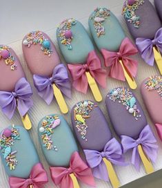 a box filled with lots of different colored candy covered in frosting and bowknots