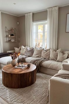 a living room filled with furniture and a coffee table in front of a large window