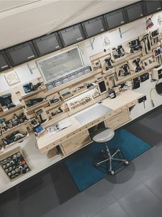 a workbench with lots of tools on the wall and desks in it