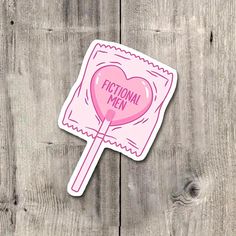 a pink sticker with the words'fictional men'written on it and a lollipop in the shape of a heart