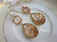 READY TO SHIP! Blush Champagne Peach Earrings Pink Gold Twisted Design - Bridesmaid Earrings Wedding Earrings Valentines Day Gift The champagne peach teardrop is 14mm by 22mm and has 16k gold plating twisted on it. The square champagne peach faceted gems are 9mm with 3mm thickness. The earwires are 14k gold filled. These earrings are so simple and classy. They can be worn for a variety of occasions - wedding, evening events, work, or simply everyday! These are also a great gift. All of my items Gold Earrings For Bridal Shower, Handmade Gold Bridal Earrings As Bridesmaid Gift, Elegant Peach Formal Jewelry, Champagne Earrings Wedding, Elegant Peach Earrings For Wedding, Peach Dangle Jewelry For Wedding, Elegant Peach Wedding Earrings, Handmade Peach Dangle Earrings, Peach Earrings