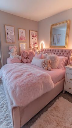 a bedroom with pink bedding and teddy bears on the pillows, rugs and mirror