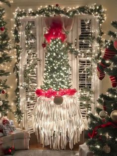 a christmas tree in the corner of a room decorated with lights and presents on the floor