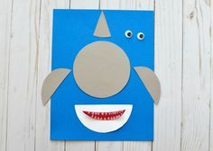 a paper cut out of a blue monster with teeth and fangs on it's face