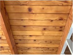 the inside of a cabin with wood paneling on the ceiling and wooden beams in the ceiling