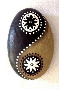 a black and white painted rock sitting on top of a table