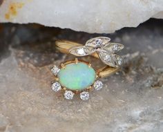 This is a 18K Yellow Gold Opal Floral Ring, Wonderful designed oval opal adorned with diamonds and leaf design with white gold accents, 5/8th inch across, circa 1950. Size 2, 3.84 Grams. Stock # BB33R21 This listing contains photographs of the actual item you will receive. Our items are in excellent condition with little or no signs of wear and many are one of a kind pre-owned estate finds. Please look closely at the pictures in this listing as they are part of the product description. Please re Opal Band, Floral Ring, Fine Jewelry Designers, Blue Topaz Ring, Topaz Ring, Opal Rings, Pink Tourmaline, Leaf Design, Gold Accents