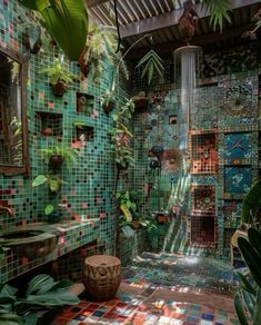 a bathroom with green tiles and plants on the walls, along with a tiled floor