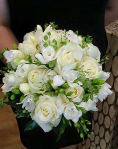 a woman holding a bouquet of white flowers