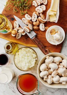 mushrooms and other ingredients on a cutting board with wine, cheese, and sauces