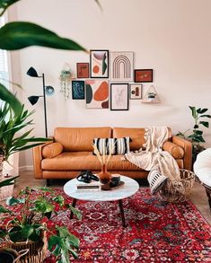 a living room filled with furniture and lots of plants on top of a red rug