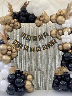 a birthday party with balloons and streamers in the shape of an arch that says happy birthday