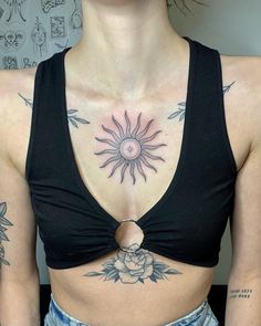 a woman with sun tattoo on her chest