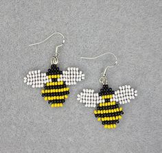 a pair of beaded earrings with a bee on it