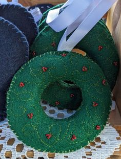 three green wreaths with white ribbons are sitting on a table next to other items