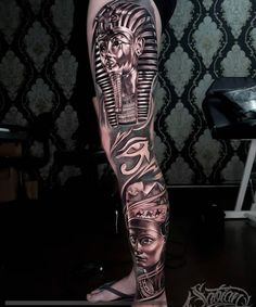 a man's leg with tattoos on it and an egyptian head in the middle