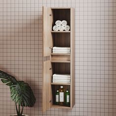 a wooden cabinet with towels on it next to a potted plant