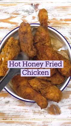 a bowl filled with fried chicken on top of a wooden table