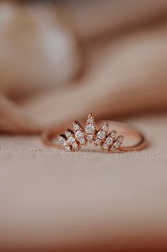 a diamond ring sitting on top of a bed