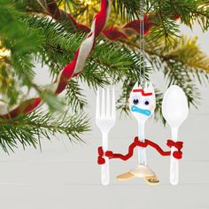 spoons and forks are hanging from a christmas ornament on a pine tree