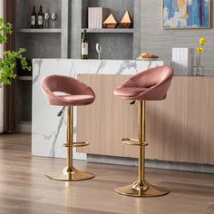 two pink velvet bar stools in front of a marble countertop and shelves with wine bottles on it