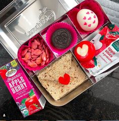 an open lunch box with cookies, crackers and candy